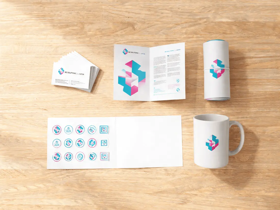 Printed business cards, stickers and branded collateral laid out on a desk